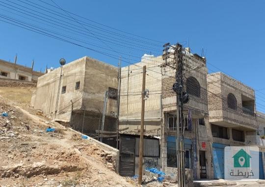 ارض عليها عماره تجاريه تصلح لبناء اسكان للبيع 